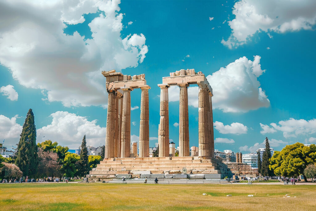 A panoramic view of the Acropolis in Athens, Greece, with the Parthenon standing proudly above the city against a clear blue sky.